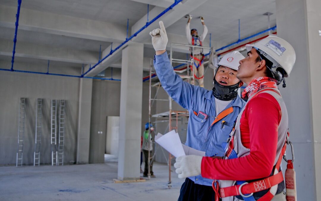 Two men in construction gear analyze a construction site.